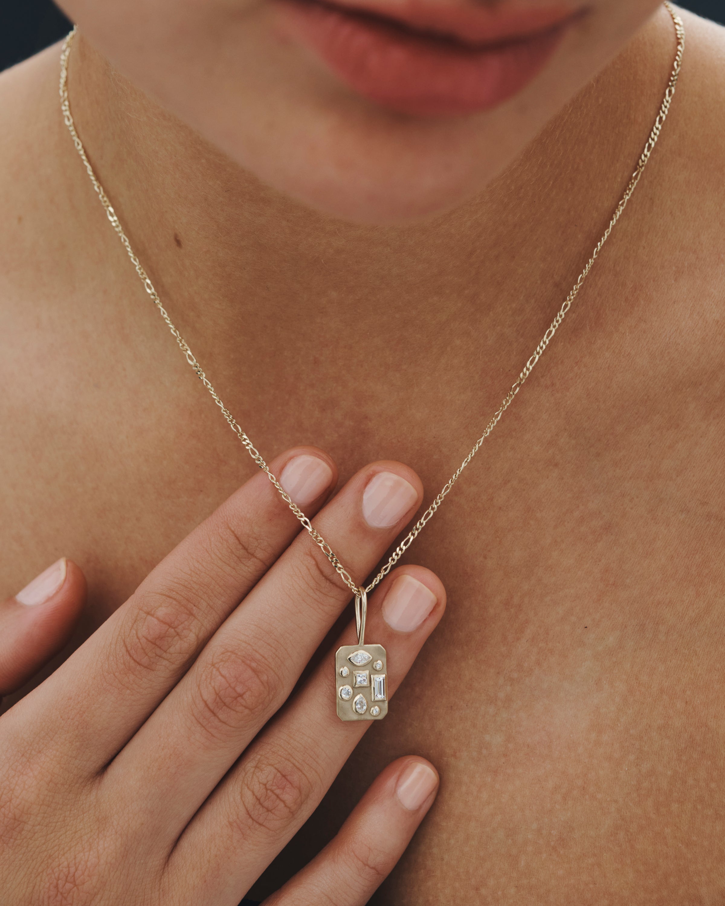 Gold necklace with a pendant worn by a person