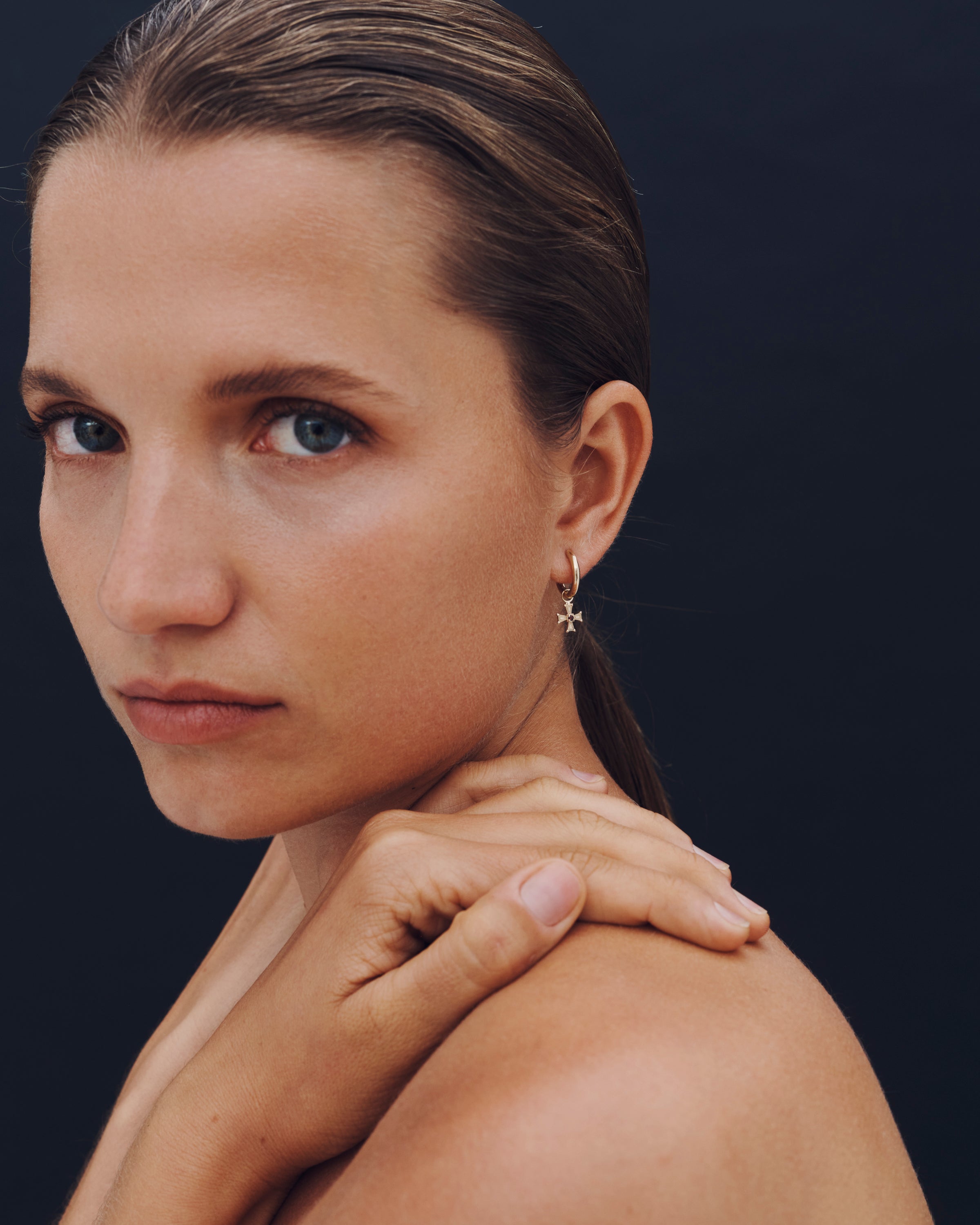 Woman with a neutral expression against a dark background
