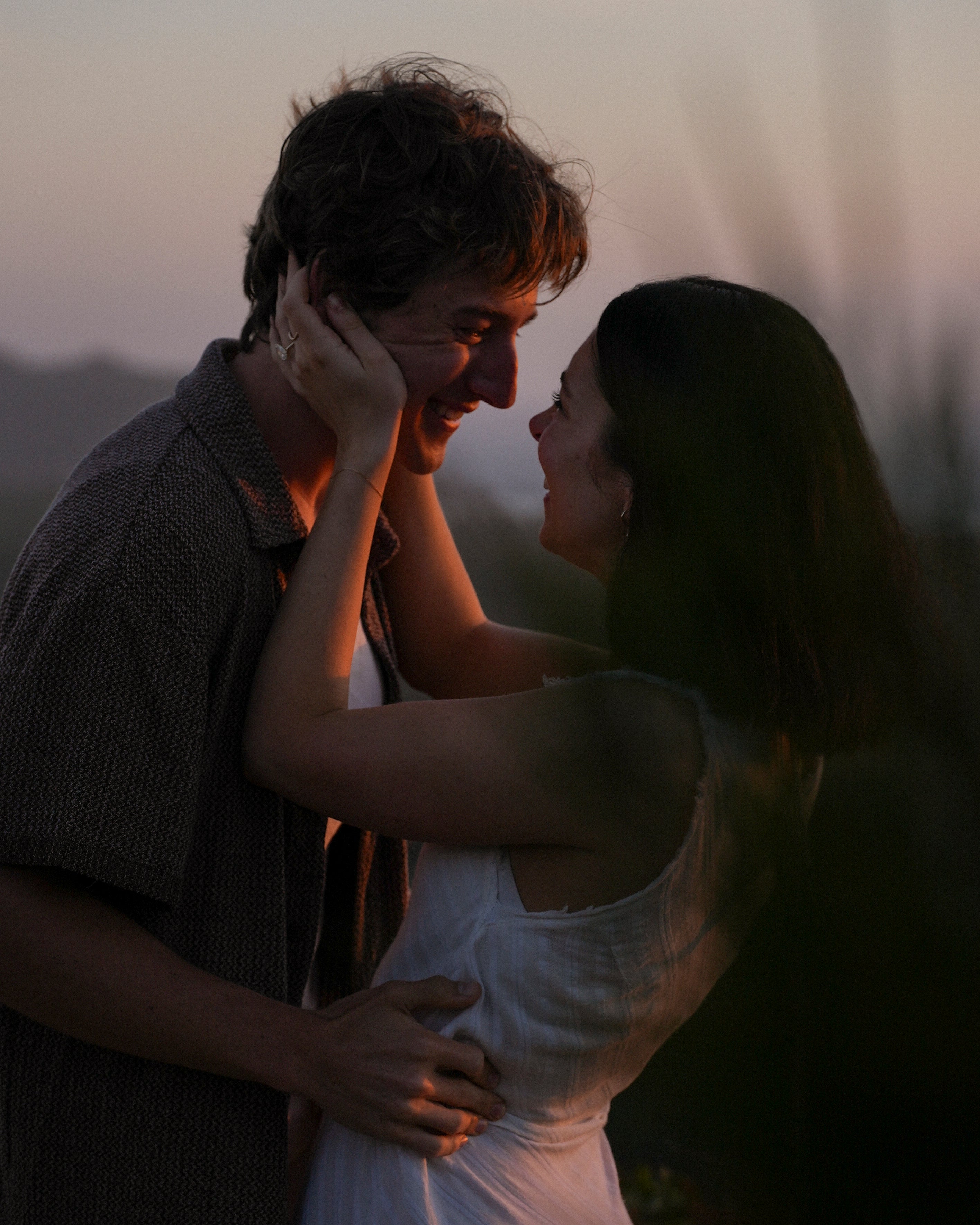 Couple embracing with a warm glow, possibly at sunset.