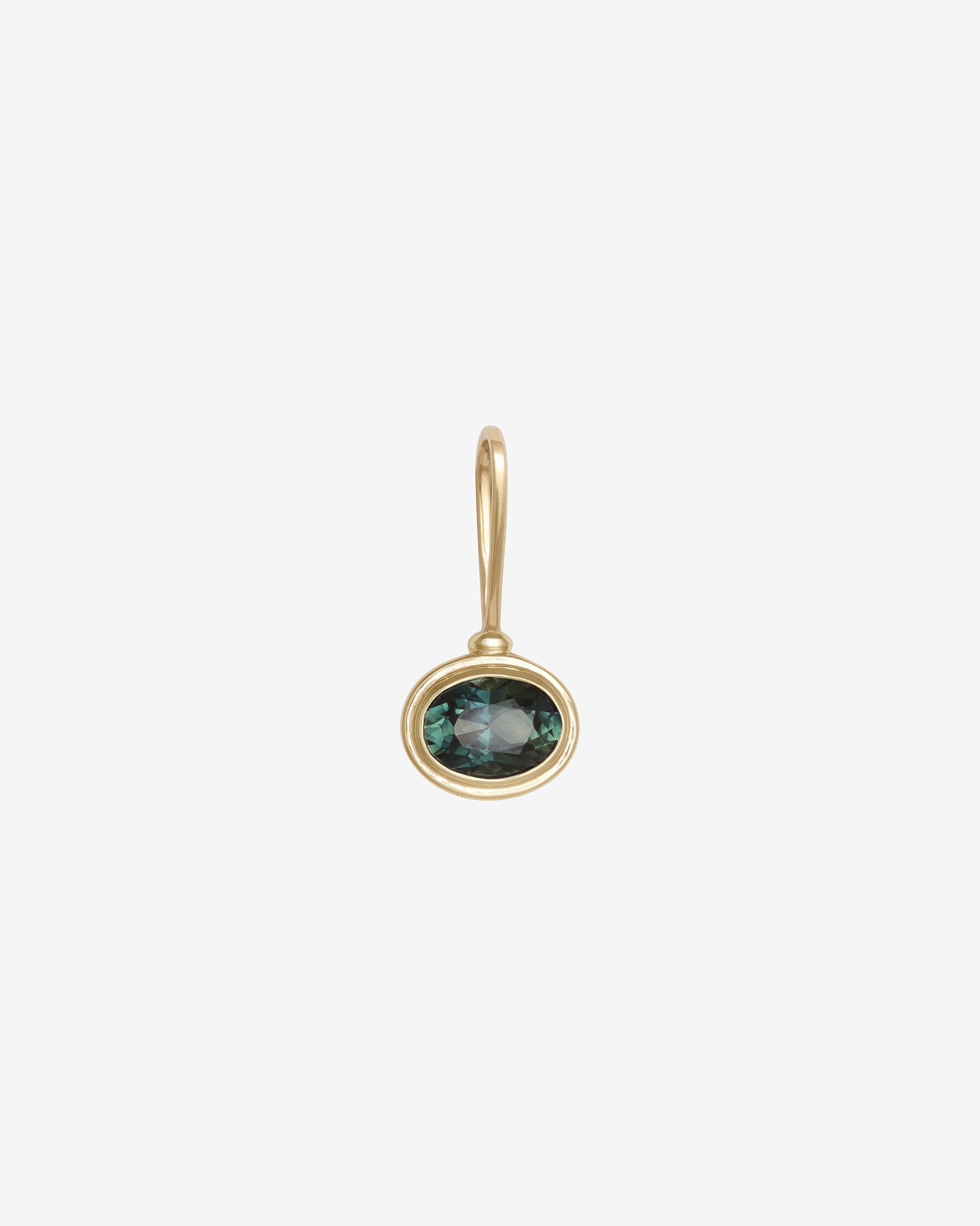 Gold earring with a green gemstone on a white background