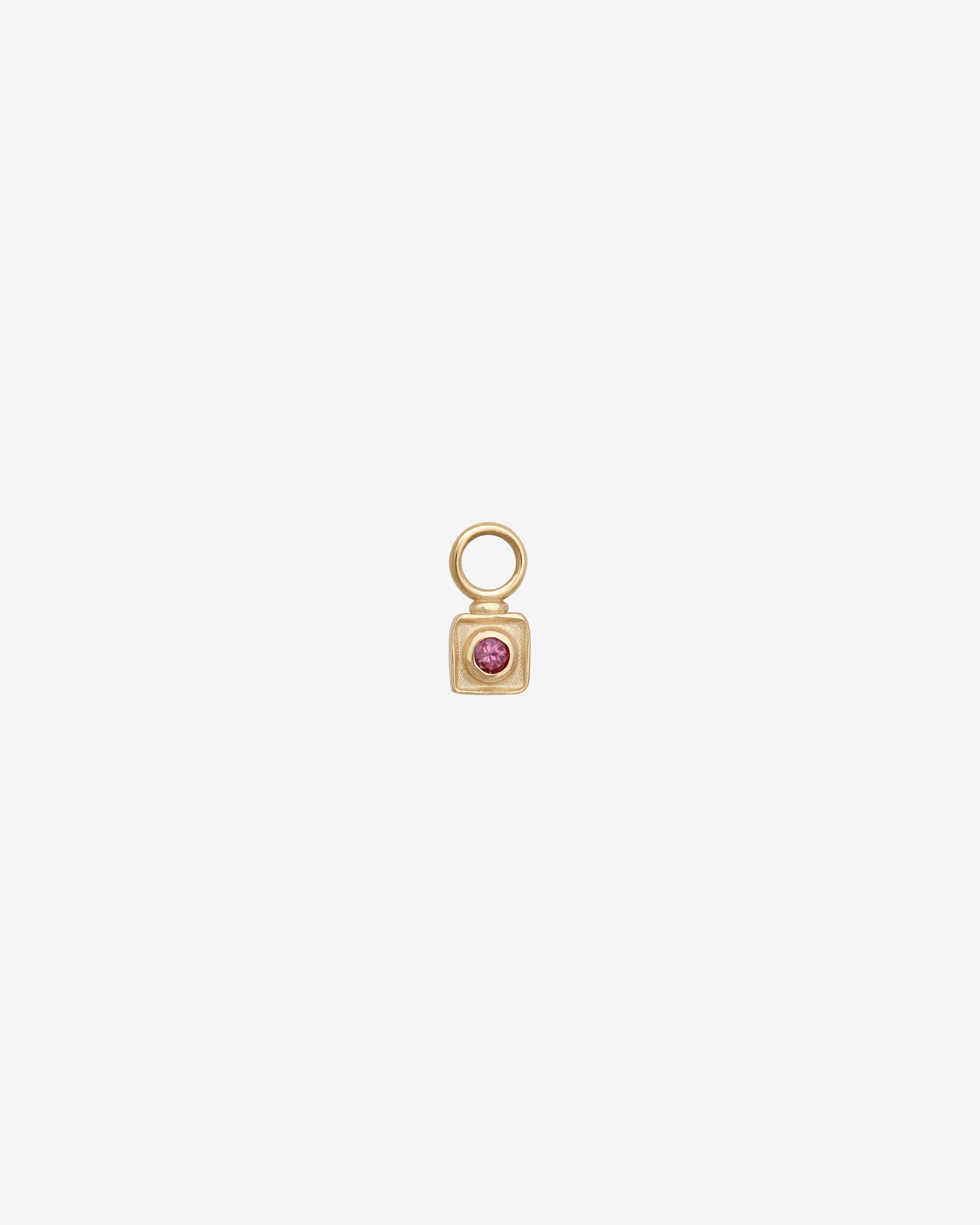 Gold charm with a pink gemstone on a white background