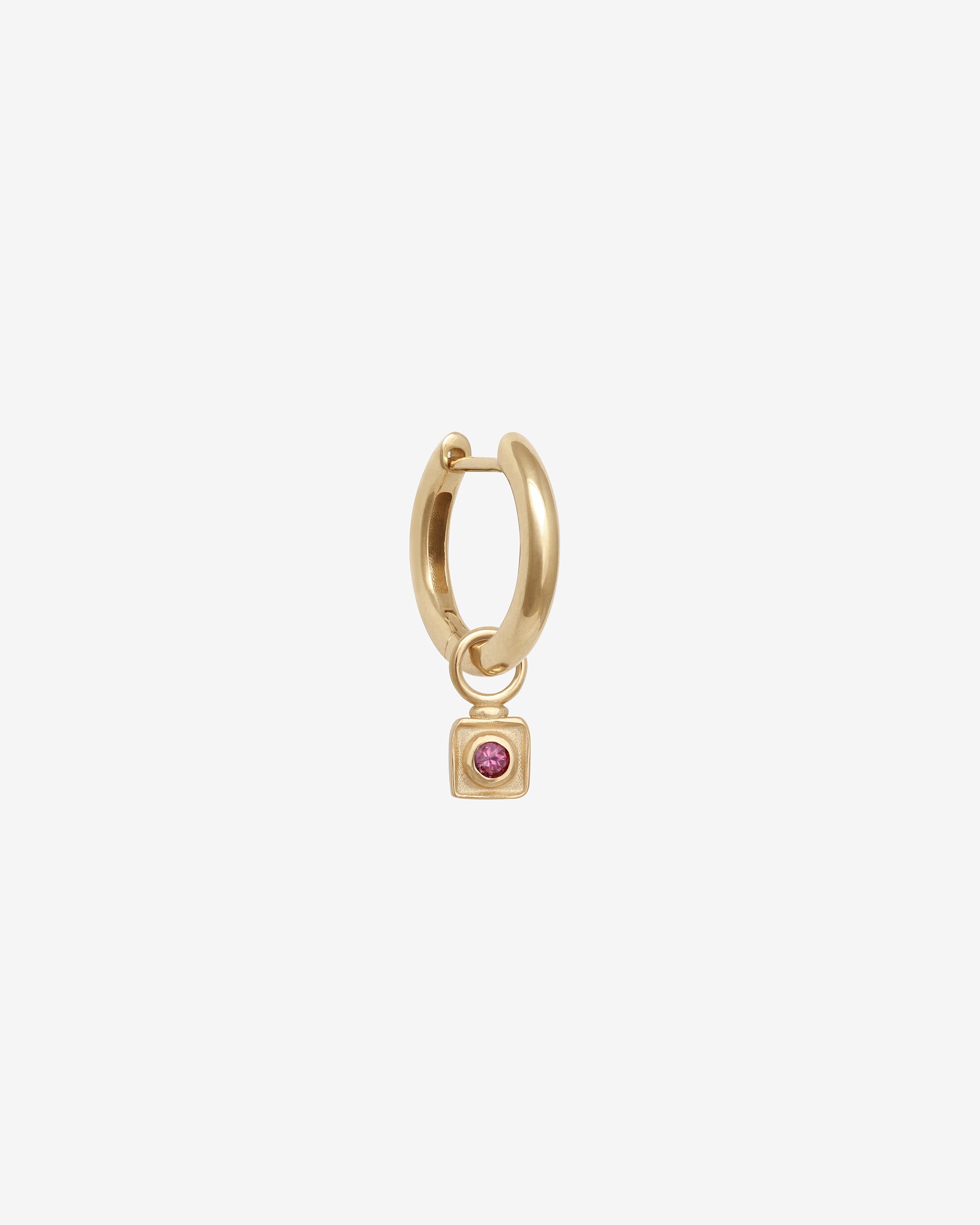 Gold hoop earring with a square pendant featuring a red gemstone on a white background