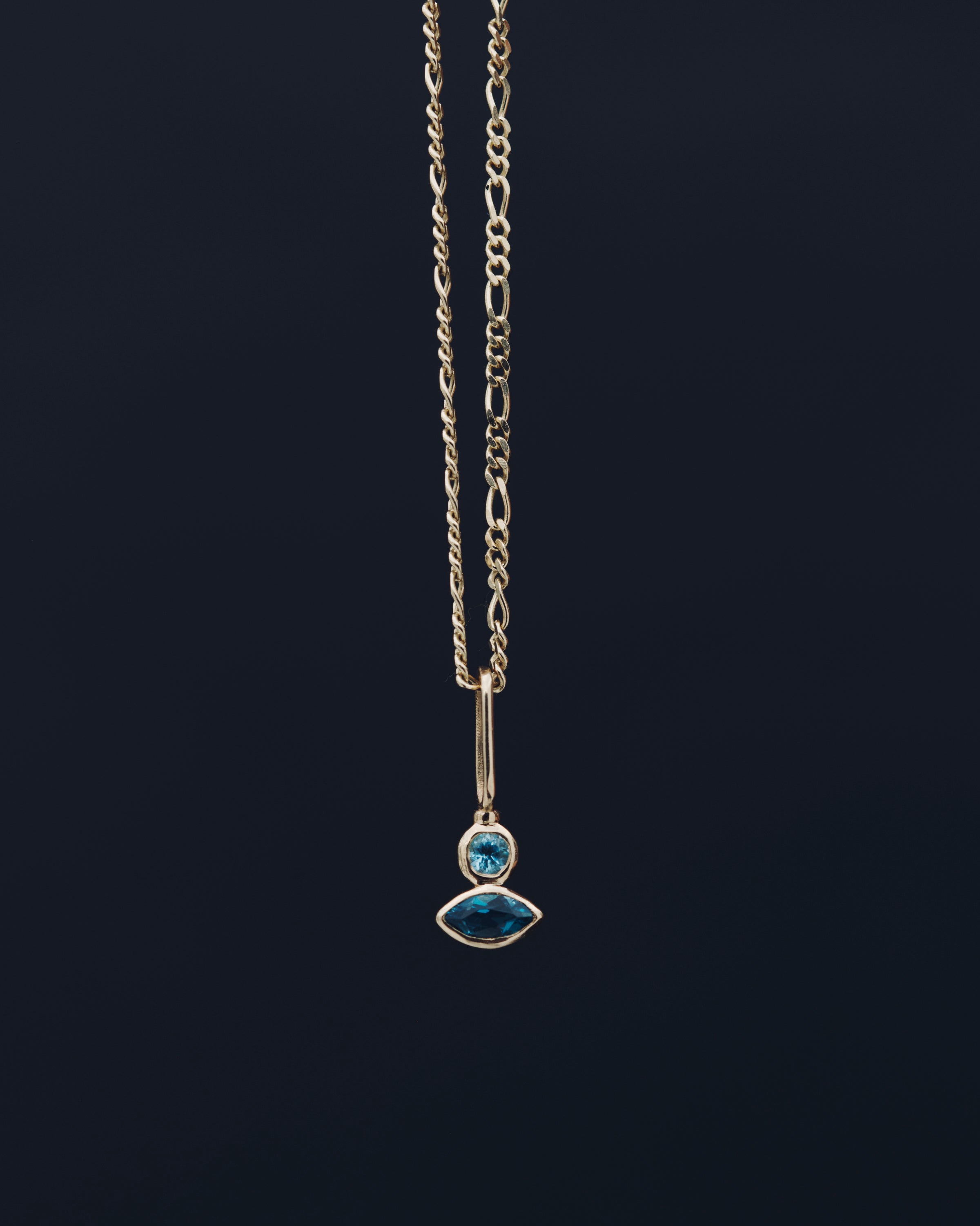 Necklace with a pendant featuring blue gemstones on a black background