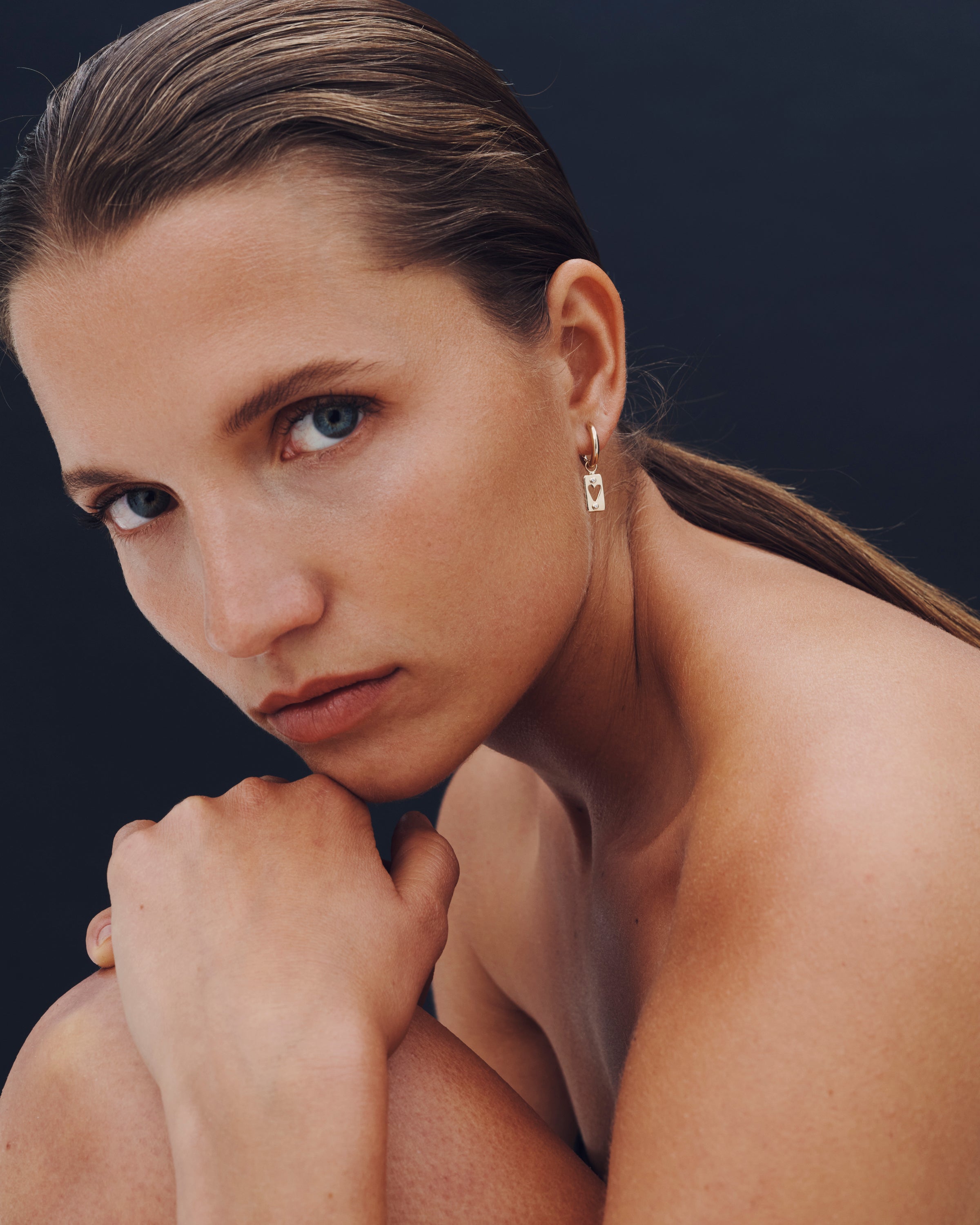 Woman with a neutral expression against a dark background