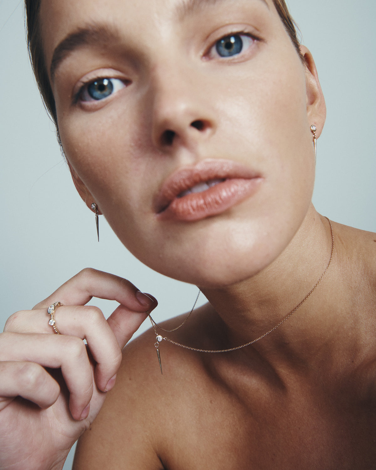 Comet Diamond Necklace and Comet Diamond Earrings in solid gold, worn at the neck