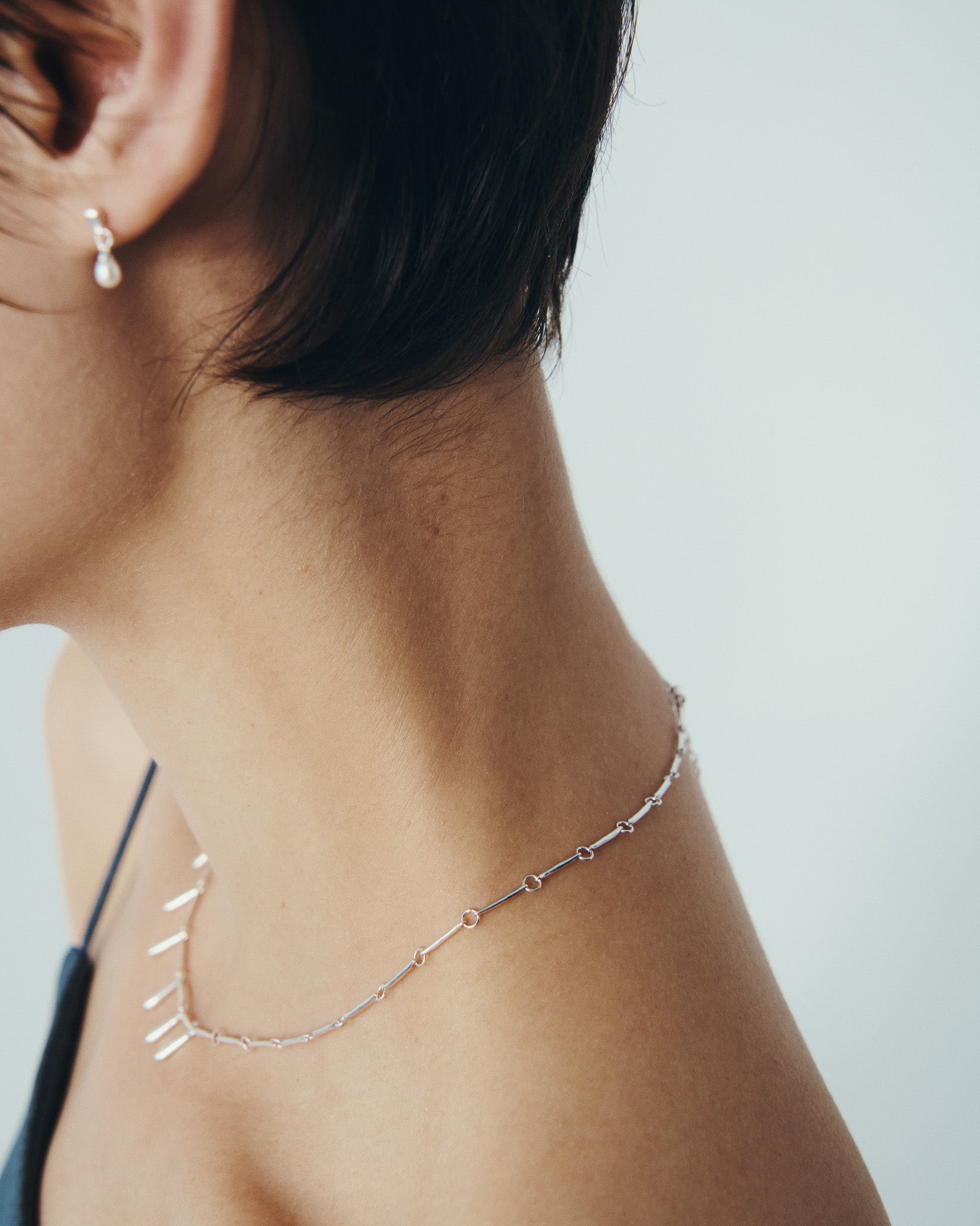 Stilla Necklace and Hydra Earrings in Silver, worn